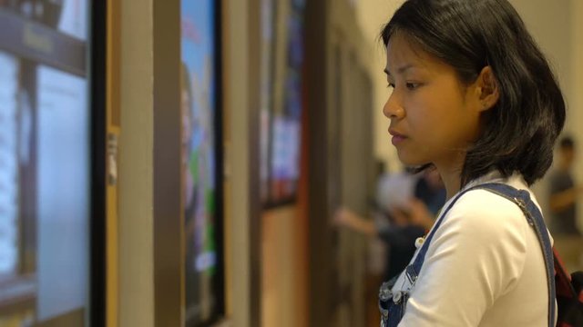 Asian Girl buying movie tickets using self-service machine 4k UHD (3840x2160)
