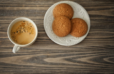 Cup of aromatic morning coffee and cookies on wooden table