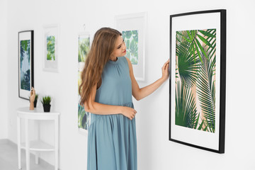 Young woman looking at picture of tropical foliage in art gallery