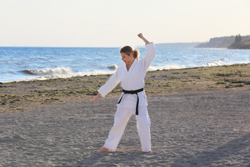 Young woman practicing karate outdoors