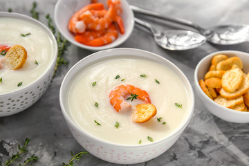 Tasty cream soup with shrimp in bowl on table