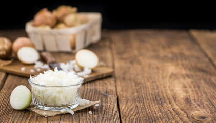 Fototapeta na wymiar White Onions (dices) on wooden background; selective focus