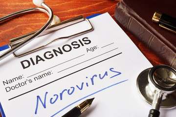 Medical form with diagnosis Norovirus on a table.