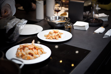 Plate with shrimps. Snack from shrimps. Fried shrimps. Cooking in the restaurant. The host shows the master class.