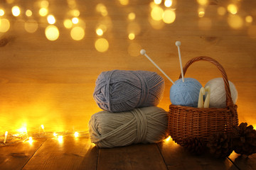 warm and cozy yarn balls of wool on wooden table.