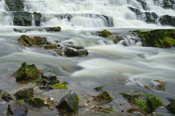 Fototapeta na wymiar River flowing over boulders.