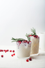 Perfect christmas cocktail: coconut margarita with cranberries and rosemary. Minimalistic concept. Linen cloth and white background. Vertical composition with copy space.