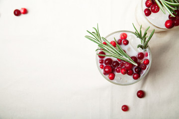 Perfect christmas cocktail: coconut margarita with cranberries and rosemary. Minimalistic concept. Linen cloth and white background. Horizontal composition with copy space. Top view.
