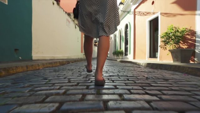 Great slow motion of woman's legs walking cobblestone streets while on vacation