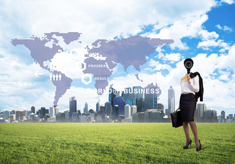 Camera headed woman standing on green grass against modern cityscape