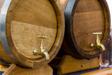 Wooden barrels for wine with a tap of yellow metal.