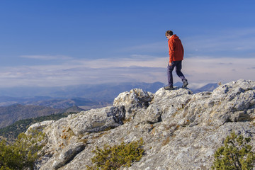 Man hiking at the peak of rock mountain. Daylight