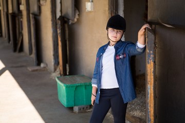 Girl standing in the stable