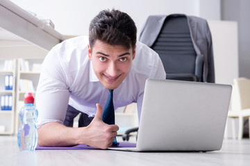 Fototapeta premium Businessman doing sports at his office space