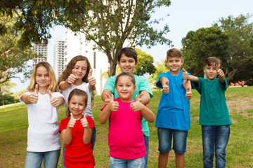 Group of happy kids showing thumbs up