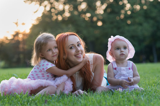 Mom with two daughters sitting in the park