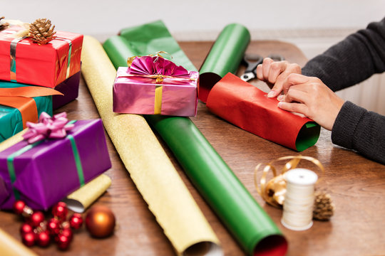 Frau packt Geschenke f&uuml;r Weihnachten, Dekoration und Geschenkpapier