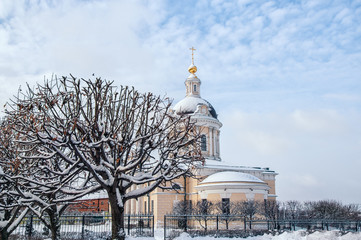 Fototapeta na wymiar Kolomna Church of the Archangel Michael with a bell tower at dawn with beautiful clouds and Golden light of late autumn in the snow.