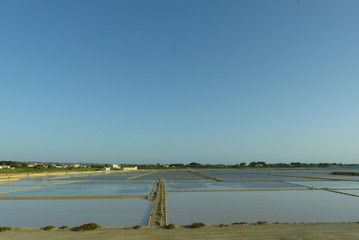 Fototapeta premium Saline di Marsala con i suoi mulini e vasche al tramonto