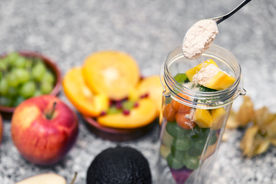 Frisches Obst in einem Smoothiemaker, Superfood Erdmandeln auf einem L&ouml;ffel