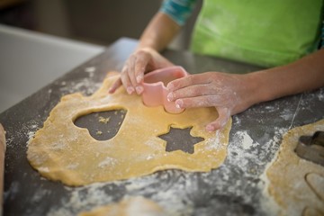 Girl cutting dough with a cookie cutter