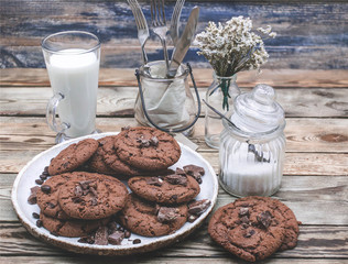 Oatmeal cookies with chocolate pieces on a wooden background with milk. Healthy breakfast concept