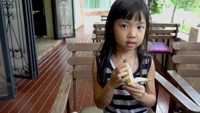 Asian Child Girl is eating banana, 5 year old