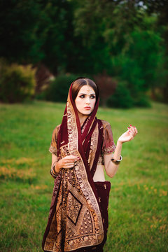 Beautiful Arabian woman portrait. Young Hindu woman with mehndi tattoos from black henna on her hands.