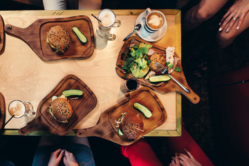 Food photography. Top view of hamburgers served with fresh vegetables, cucumbers on wooden boards in rustic style