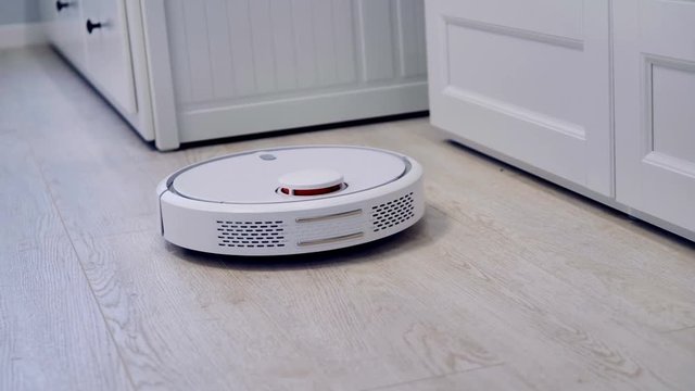 Detailed view on a self-moving robotic vacuum on the floor.    