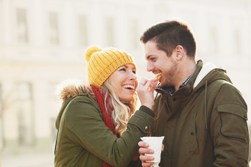 Smiling couple having hot drink outdoors  in an autumn day.