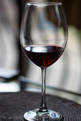 A wineglass of red wine on a round tissue place mat. Close up.