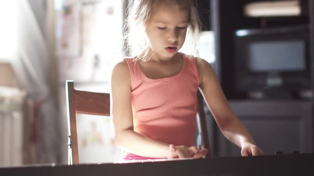 little girl 6 years learning to play the piano. the child rehearses a piece of music
