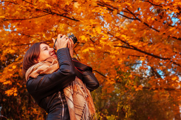 Young photographer takes pictures of autumn forest