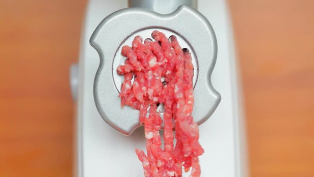 The manufacture of minced meat. Mincer turns the meat in the mince.