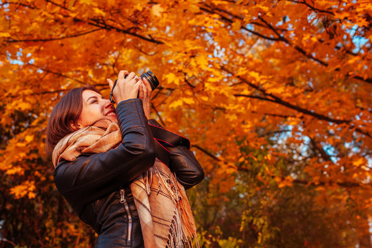 Young photographer takes pictures of autumn forest