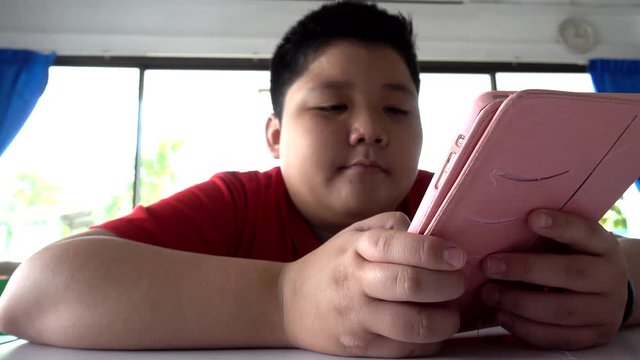 Asian child Boy are addictive playing tablet and mobile phones, Game Addiction