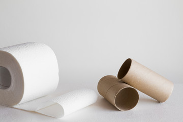 White toilet paper roll with empty rolls on the gray background. Hygiene concept. Empty place for text.