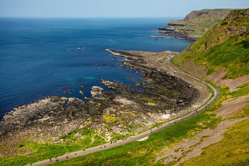 Thousands of tourists visiting Giant's Causeway in County Antrim of Northern Ireland, a World Heritage Site by UNESCO containing about 40000 interlocking basalt columns from ancient volcanic eruption