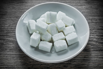 Sugar cubes plate on wooden board