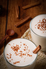 Eggnog houmemade with cinnamon and kakao for Christmas and winter holidays or wooden broun backgrounds