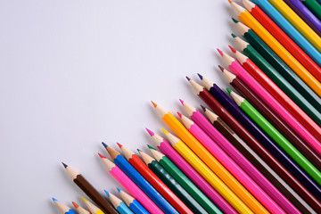Colored crayons background. Many different colored pencils on white background