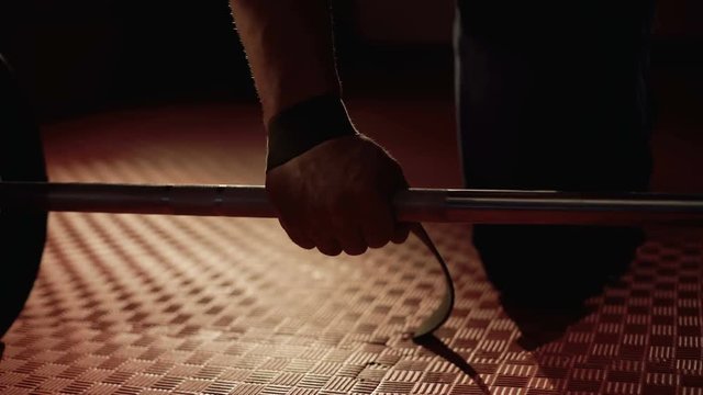 Close-up male bodybuilder's hand takes weights. 4K