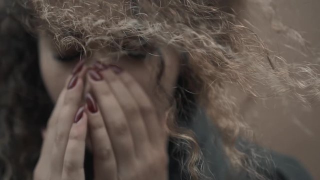 Depressed woman holding face in hands, young crying girl student close up, emotional portrait with tears