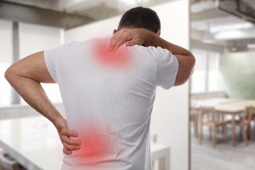 Muscular Man suffering from back and neck pain. Incorrect sitting posture problems Muscle spasm,...