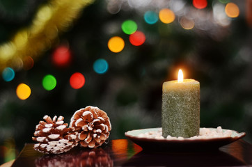 Christmas picture with a lit candle and pine cones