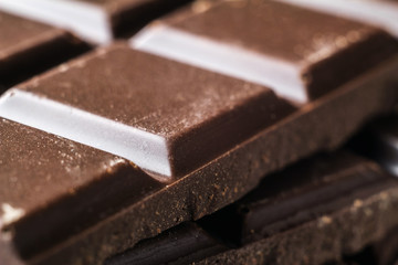 Bitter dark chocolate pieces on the heap, selective focus, macro image