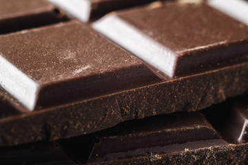 Bitter dark chocolate pieces on the heap, selective focus, macro image