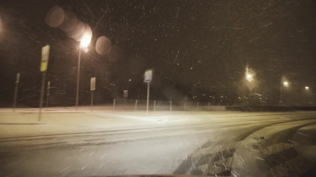 By car on a snowy road in a winter city