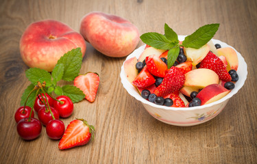 Delicious fruit salad on a wooden background.